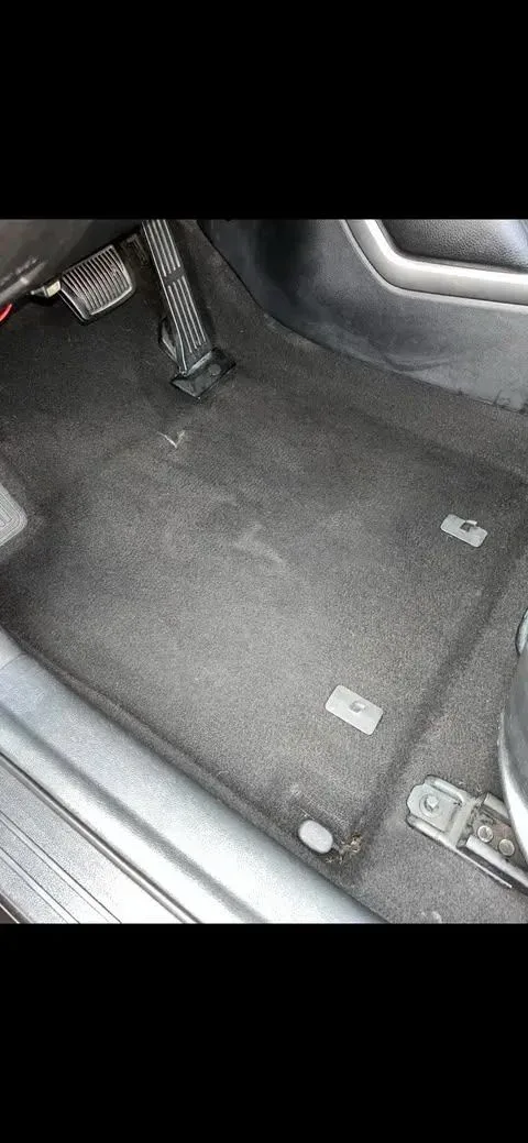 The same driver footwell after detailing with clean carpet